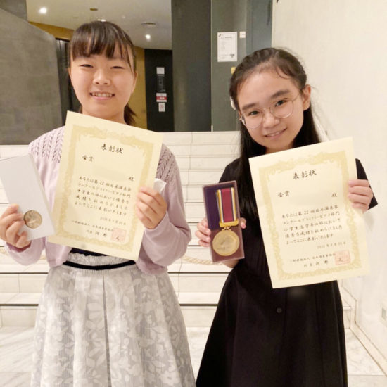 コンクールの賞状とメダルを持った女の子2名の記念写真